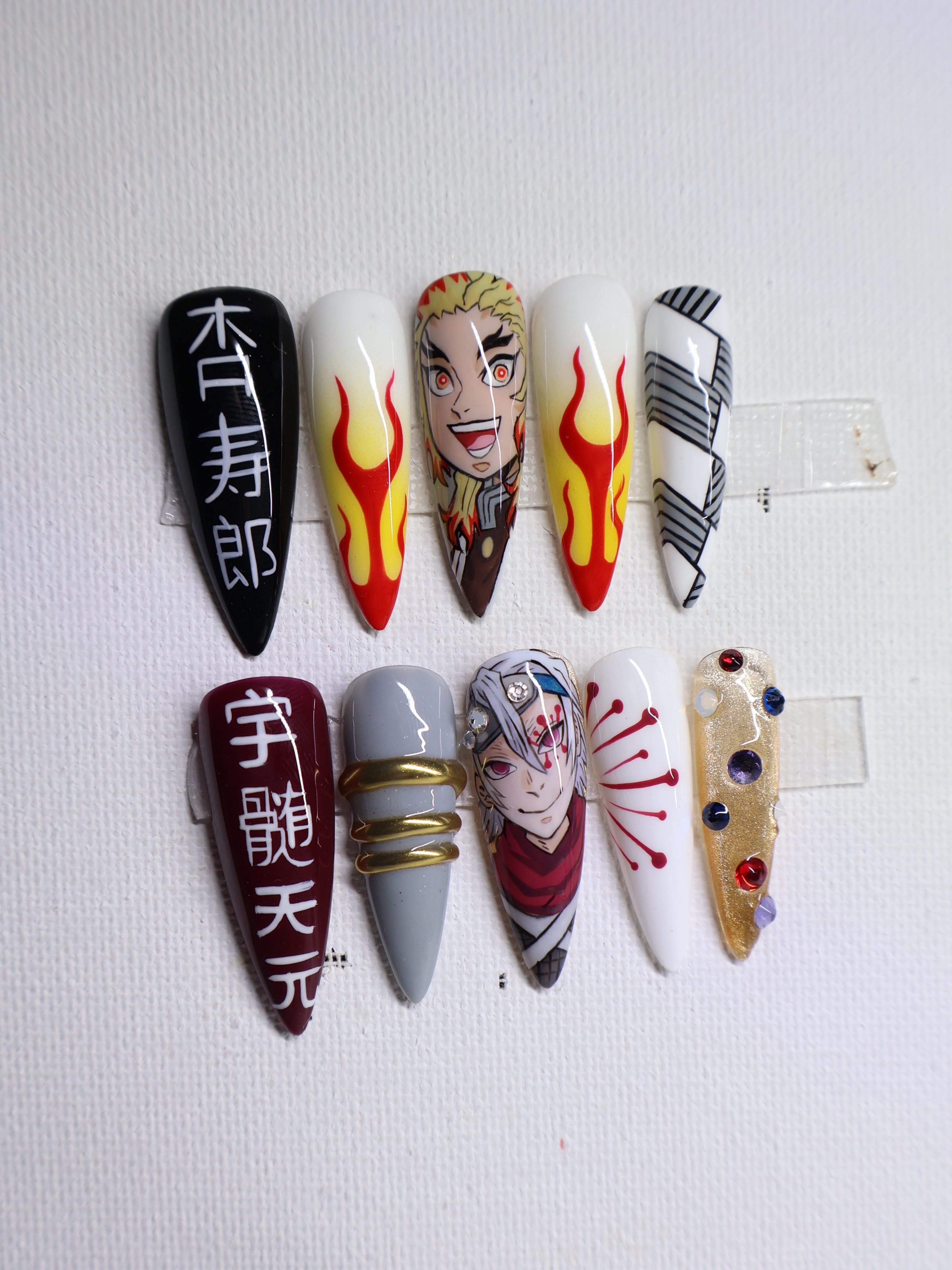 Hand-painted Demon Slayer press-on set: Kyojuro Rengoku and Tengen Uzui portraits, kanji names, flames and gems